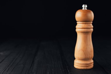 Tahta masadaki baharatlar için kahverengi kabın yakın plan görüntüsü 