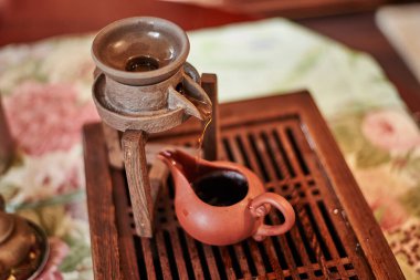 Geleneksel çay seremonisi sırasında Asya tarzında kil çaydanlığın yakın görüntüsü            