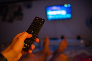 TV uzaktan kumanda tutan erkek el. Bakış açısı vurdu