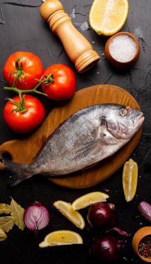 Limon dilimli, domatesli, siyah üzerine baharatlı leziz taze balık manzarası.