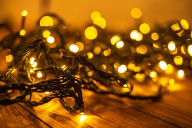 Kahverengi ahşap arka planda ışıklandırılmış çelenk ile şenlikli Noel arkaplanı