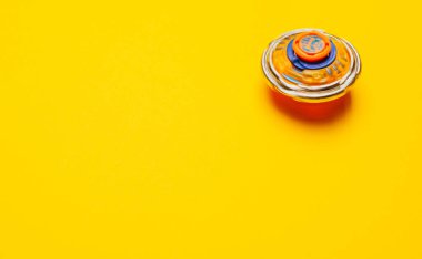 Sarı zemin üzerinde dönen Beyblade oyuncağının yakın plan görüntüsü