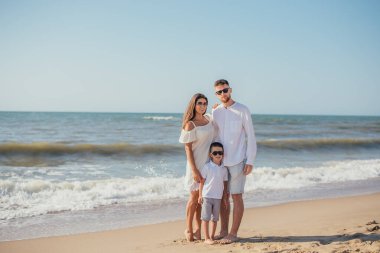 Yazın kumsalda tek çocuklu mutlu bir aile.