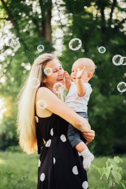 Mutlu anne parkta oğluyla oynuyor.