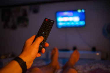 TV uzaktan kumanda tutan erkek el. Bakış açısı vurdu