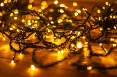 Noel arkaplanı, kahverengi ahşap arka planda aydınlatılmış şenlik çelengi. 