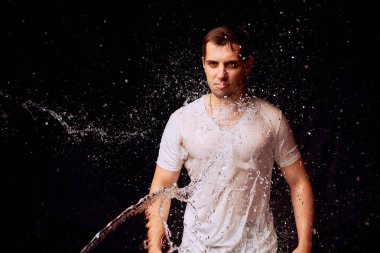 Karanlık arka planda genç adam su Sıçramaları