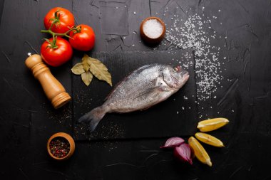 Limon dilimleri, domatesler ve körfez yapraklı lezzetli taze balık manzarası.