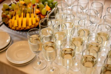 Şenlik masasında yüksek açılı şampanya kadehleri ve meyveler.  