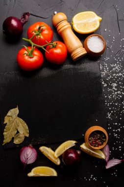 Siyah arka planda yemek ve baharat malzemeleri.