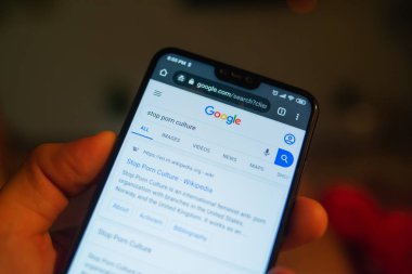 Akıllı telefon ve internet sitesi tutan kişinin kırpılmış görüntüsü