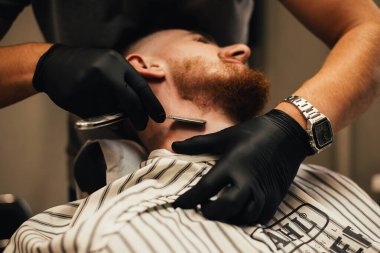 Berber dükkanındaki adama sakal tıraşı olmanın kısmi görüntüsü