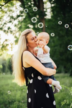 Mutlu anne parkta oğluyla oynuyor.