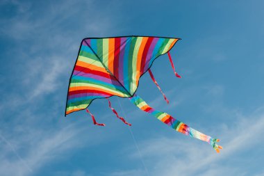 Mavi gökyüzünde uçan renkli uçurtmanın düşük açılı görüntüsü 