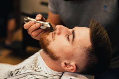 Ustanın berber dükkanında saç ve sakal keserken çekilmiş resmi.