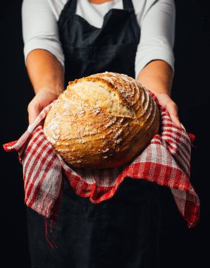 Fırıncının elinde taze pişmiş ekmek tutarken kısmi görüntüsü