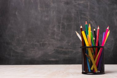 Masadaki okul malzemelerinin yakın görüntüsü ve kopya alanı olan karatahta