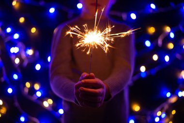 Noel 'de elinde maytap tutan çocuğun yakın plan görüntüsü.