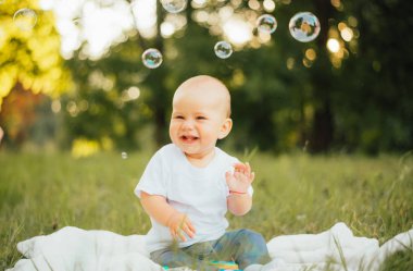 Yazın sabun köpüğü olan küçük sevimli bir çocuk.