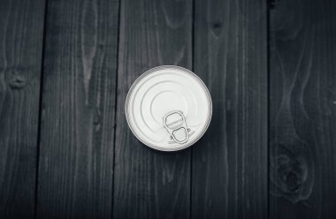 Koyu ahşap masadaki metal kutunun yakın çekim görüntüsü.