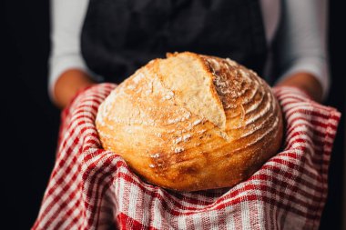 Fırıncının elinde taze pişmiş ekmek tutarken kısmi görüntüsü