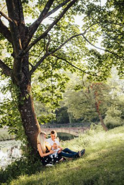 Genç ebeveynler ve erkek çocukları yazın dışarıda.