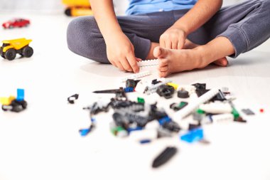 İnşaat plastik oyuncak bloklarıyla oynayan küçük bir çocuk, evde renkli oyuncaklarla oynayan bir çocuk.