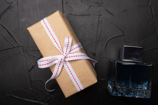 top view of gift box and bottle of perfume on black background