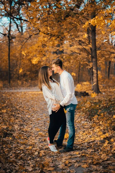 美丽快乐的年轻夫妇在秋天的公园拥抱的侧视图 — 图库照片