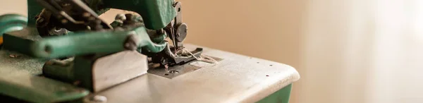 close-up view of green vintage sewing machine at workplace