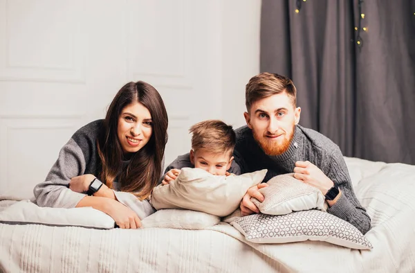 Feliz Familia Joven Con Niño Acostado Juntos Cama Sonriendo Cámara — Foto de Stock