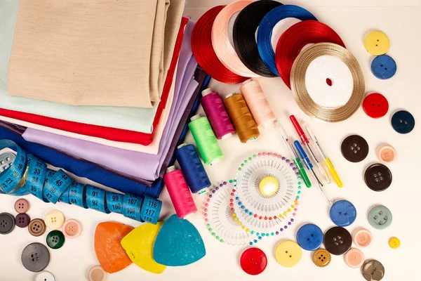 Sewing accessories and fabric. Sewing threads, needles, pins, fabric, buttons and sewing centimeter.
