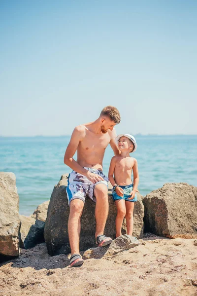 Щасливий Батько Син Купальнику Сидячи Разом Скелі Пляжі — стокове фото