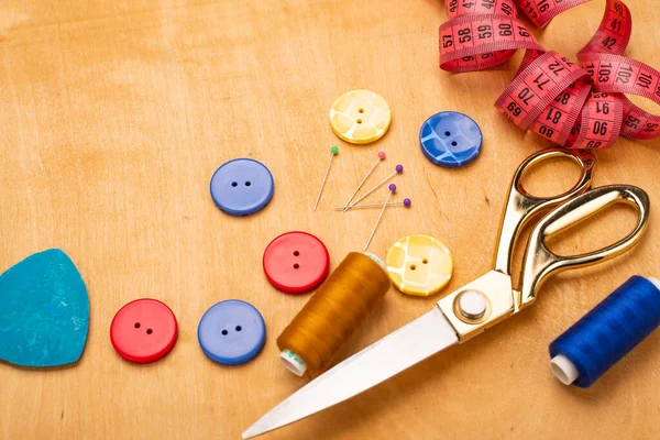 top view of sewing accessories on wooden table background