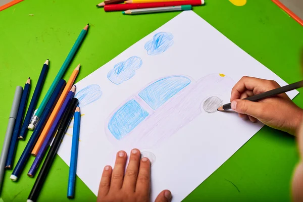 Маленький Мальчик Рисует Машину Карандашом Столом — стоковое фото