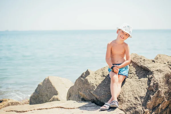 Słodkie Szczęśliwy Dziecko Siedzi Skale Piaszczystej Plaży Okresie Letnim — Zdjęcie stockowe