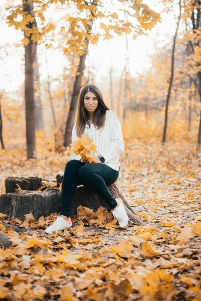 Attraente Giovane Donna Che Tiene Foglie Gialle Sorride Alla Macchina — Foto Stock