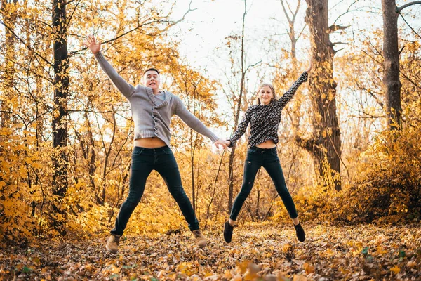 Hermosa Feliz Joven Pareja Cogida Mano Saltando Parque Otoño —  Fotos de Stock