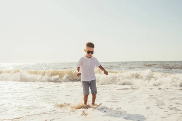 Urocze Szczęśliwe Dziecko Szortach Okularach Słonecznych Biegających Piaszczystej Plaży — Zdjęcie stockowe