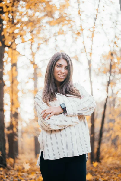秋の森の中のカメラで微笑む魅力的な若い女性 — ストック写真