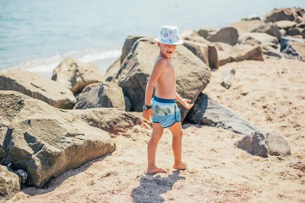 Adorable Niño Pantalones Cortos Sombrero Caminando Playa Arena Con Rocas — Foto de Stock