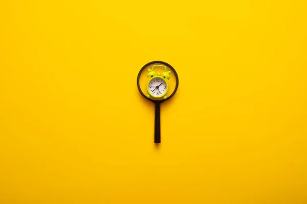 Draufsicht Auf Lupe Und Wecker Auf Gelbem Hintergrund — Stockfoto