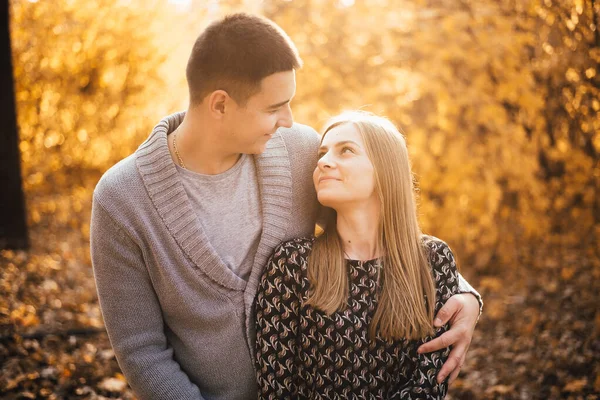 美丽快乐的年轻夫妇在秋天的公园里互相拥抱 互相微笑 — 图库照片