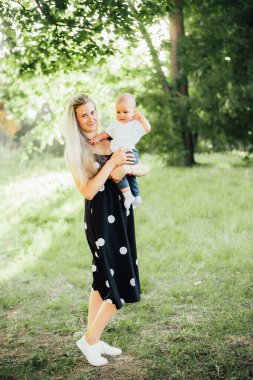 Annesiyle birlikte yaz parkında sevimli bir çocuk.