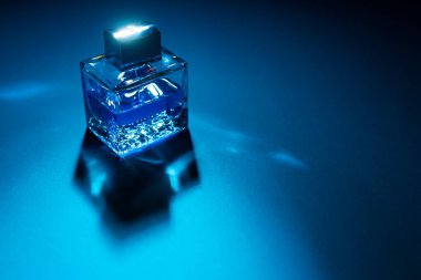 Mavi arka planda erkek parfümünün yakın plan görüntüsü 