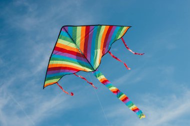 Mavi gökyüzünde uçan renkli uçurtmanın düşük açılı görüntüsü 