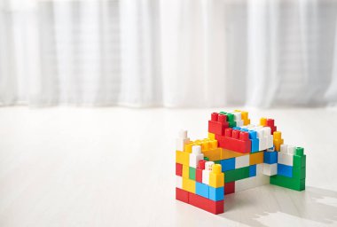 Gri ahşap arka planda parlak renkli plastik yapı taşları. Oyuncak geliştiriyorum. Erken öğrenme. 