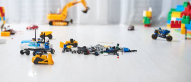 Gri ahşap arka planda parlak renkli plastik yapı taşları. Oyuncak geliştiriyorum. Erken öğrenme. 