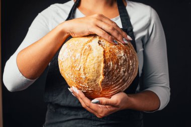 Yakından bakınca fırıncının elinde taze pişmiş ekmek tuttuğunu görüyoruz.