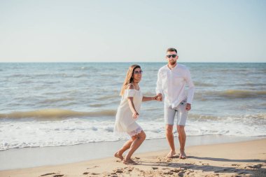 Mutlu genç çift kumsalda birlikte vakit geçiriyor.